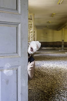Murderer hiding in abandoned house door, halloween