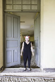 Clown in abandoned house door, fear and halloween