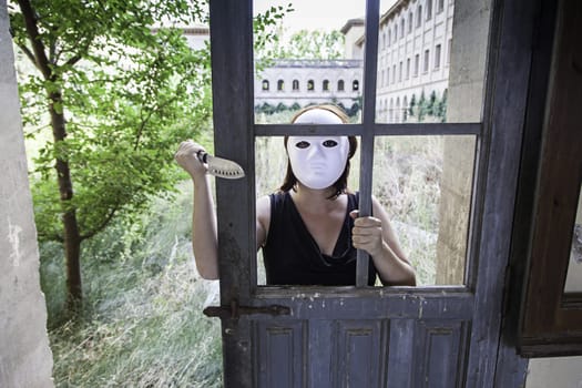 Murderer hiding in abandoned house door, halloween