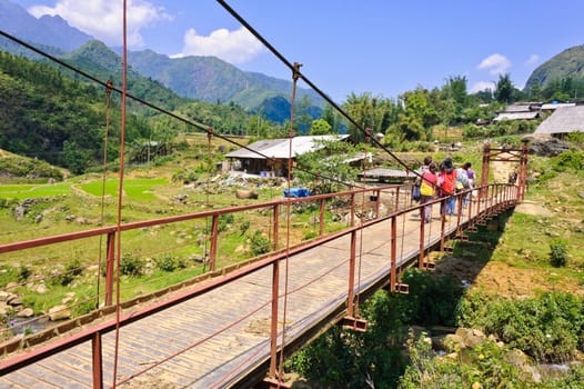 Tourist across a red bridge in Sapa, Vietnam