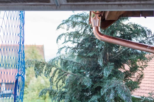 A new gutter, drain, made of copper.