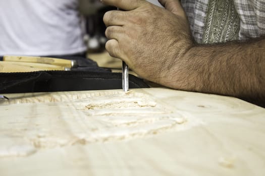 Man carving wooden board, work and crafts