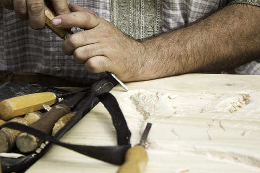 Man carving wooden board, work and crafts