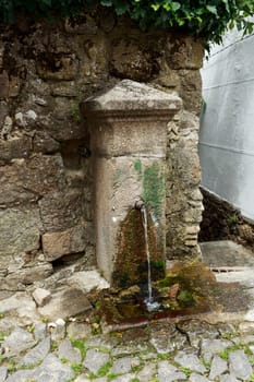 Small fountain with continuous running water found in a narrow street of Linhares da Beira, Beira Alta, Portugal