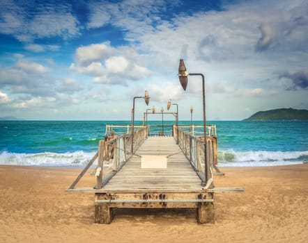 Scenic view of Nha Trang beach at sunny day. Beautiful tropical landscape. Pier on the foreground