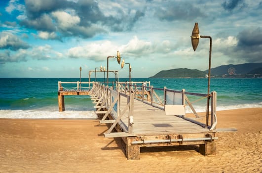 Scenic view of Nha Trang beach at sunny day. Beautiful tropical landscape. Pier on the foreground