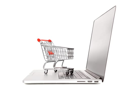Laptop with small shopping cart isolated in white