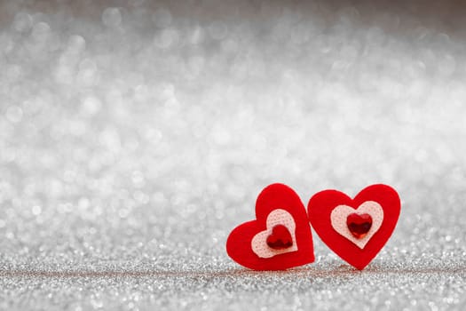 Two decorative hearts on a glittering gold background with copy space. Valentine's Day card. Design element for romantic greeting card, wedding invitation