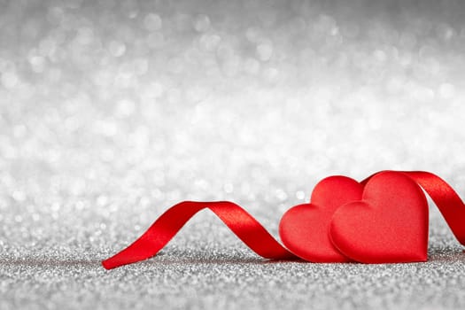 Two decorative hearts on a glittering silver background with copy space. Valentine's Day card. Design element for romantic greeting card, wedding invitation