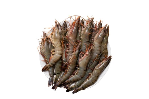 Seafood background. Closeup of raw tiger shrimps on a plate isolated on a white background. Top view.