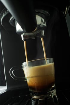 Espresso coffee pouring from coffee machine. Professional coffee brewing