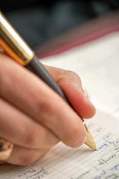 Successful entrepreneur and businessman. Hand of the men conducting the negotiations. Man writing at the desk. Hands with piece of paper or document and pen. Signing the contract. Confident man with pen and ring on hand. Leader Manager. Hand with pen when signing document.
