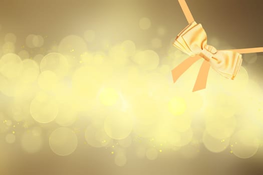 Card concept for Invitation, greetings or holidays. A decorative gold shiny bow made of satin with painted ribbons over gold bokeh lights background. Template for your product display montage. Beautiful texture.