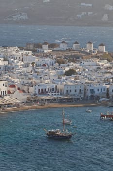 panoramic view of the Mykonos town harbor with famous windmills from the above hills on a sunny summer day, Mykonos, Cyclades, Greece