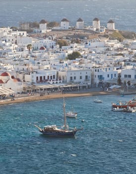 panoramic view of the Mykonos town harbor with famous windmills from the above hills on a sunny summer day, Mykonos, Cyclades, Greece