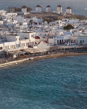 panoramic view of the Mykonos town harbor with famous windmills from the above hills on a sunny summer day, Mykonos, Cyclades, Greece
