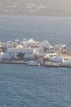 panoramic view of the Mykonos town harbor with famous windmills from the above hills on a sunny summer day, Mykonos, Cyclades, Greece