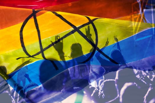 silhouette of a parade of gays and lesbians with a rainbow flag - symbol of love and tolerance