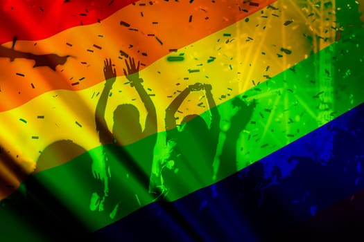 silhouette of a parade of gays and lesbians with a rainbow flag - symbol of love and tolerance