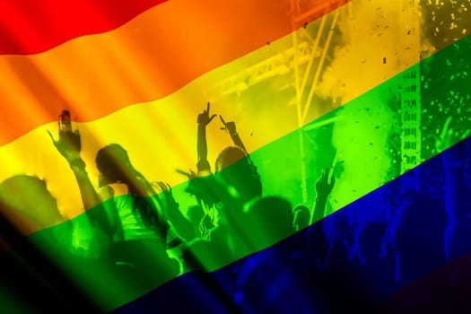 silhouette of a parade of gays and lesbians with a rainbow flag - symbol of love and tolerance