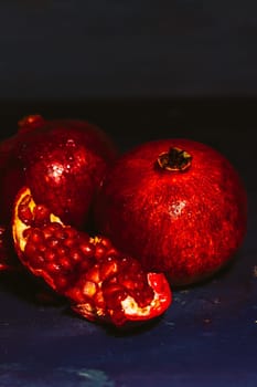 red sliced pomegranate on a blue abstraction background.