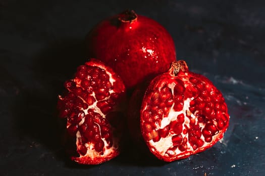 red sliced pomegranate on a blue abstraction background.