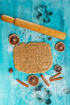Gingerbread dough with molds for baking cinnamon on blue wooden table.