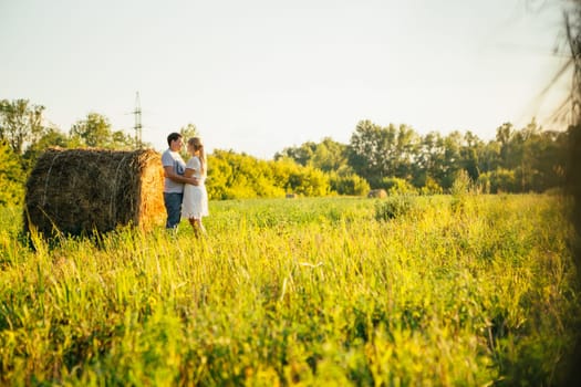 love story man and woman on the background of haystacks and sun.