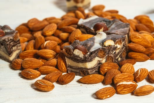 candy paste and almonds on white wooden background.