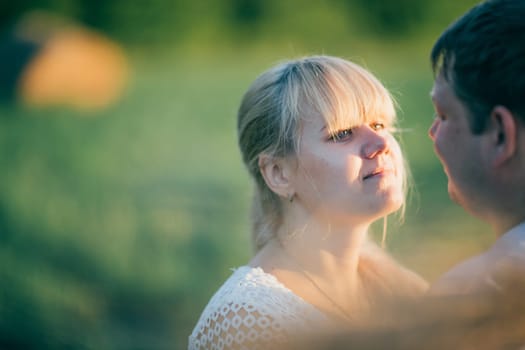portrait of love story man and woman on the background of haystacks and sun.