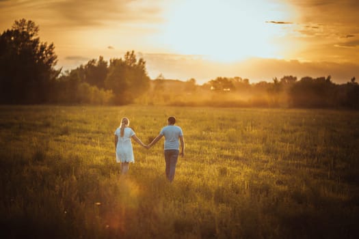 love story man and woman on the background of haystacks and sun.