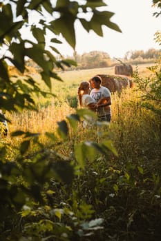 love story man and woman on the background of haystacks and sun.