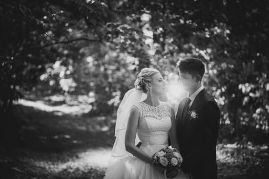 black and white photo portrait of the bride and groom on the forest background.