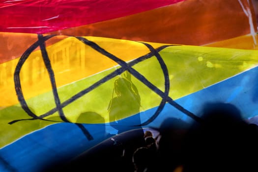 silhouette of a parade of gays and lesbians with a rainbow flag - symbol of love and tolerance