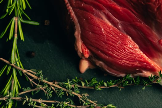 raw beef meat with spices on slate stone kitchen board.