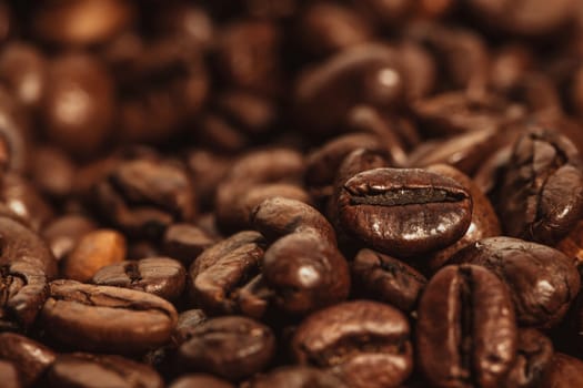 Dark many roasted coffee beans texture background.