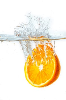 orange halves falling into water on white background