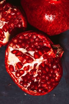 red sliced pomegranate on a blue abstraction background.