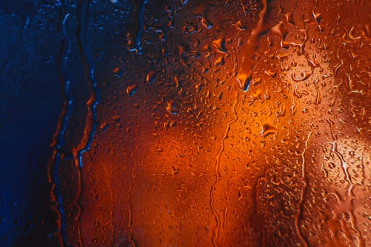 Drops of rain on the window of the car in the evening.