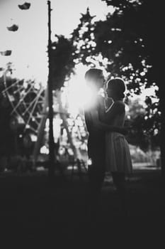 guy and the girl hugging at amusement background.