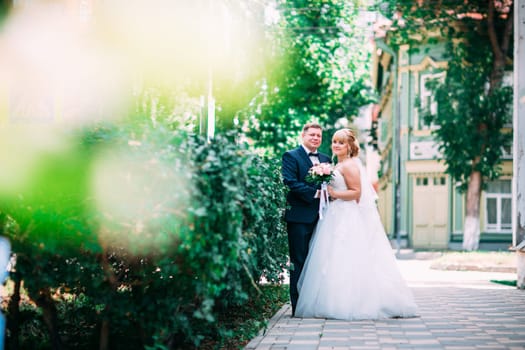 bride and groom on the background of the garden fence.