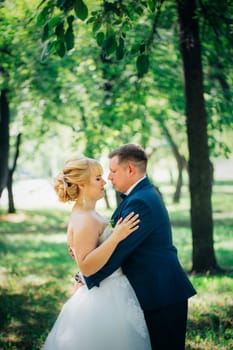 couple bride and groom on the background of the park's trees.