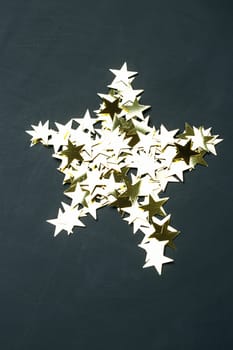 Star of sequins on a black background.