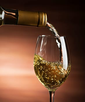 White wine pouring into wine glass, close-up - Image