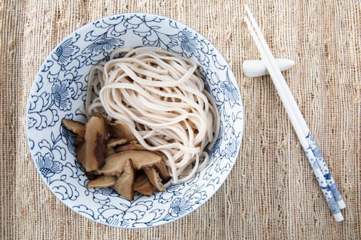 Filling bowl with udon noodle soup series image three: bowl with noodles and shiitake mushrooms