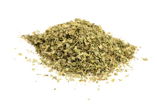 Heap of dried cilantro leaves isolated on a white background.
