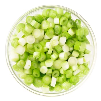 Chopped spring onions in a glass bowl and isolated on a white background.