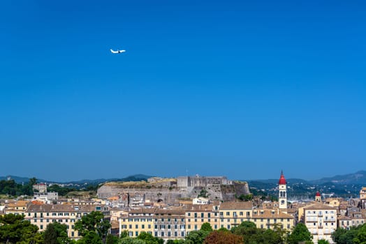 Airplane flying over the old town of Corfu, Greece with the New Fortress in the background