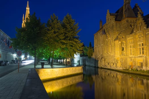 Dijver canal and tower of the Church of Our Lady at night (Bruges, Belgium). Horizontally.