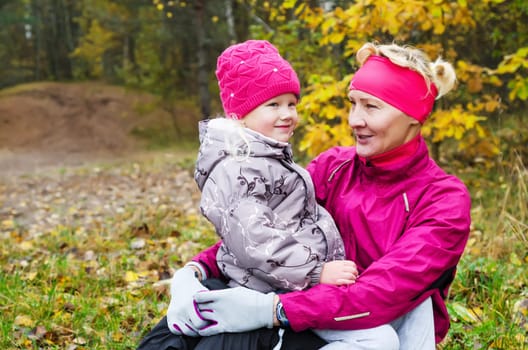 Grandmother with her granddaughter in the autumn park